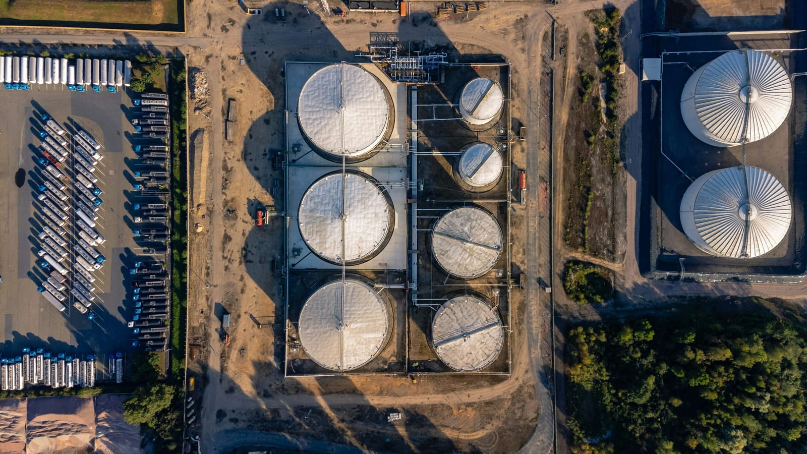 White storage tanks in a coastal tank farm seen from above