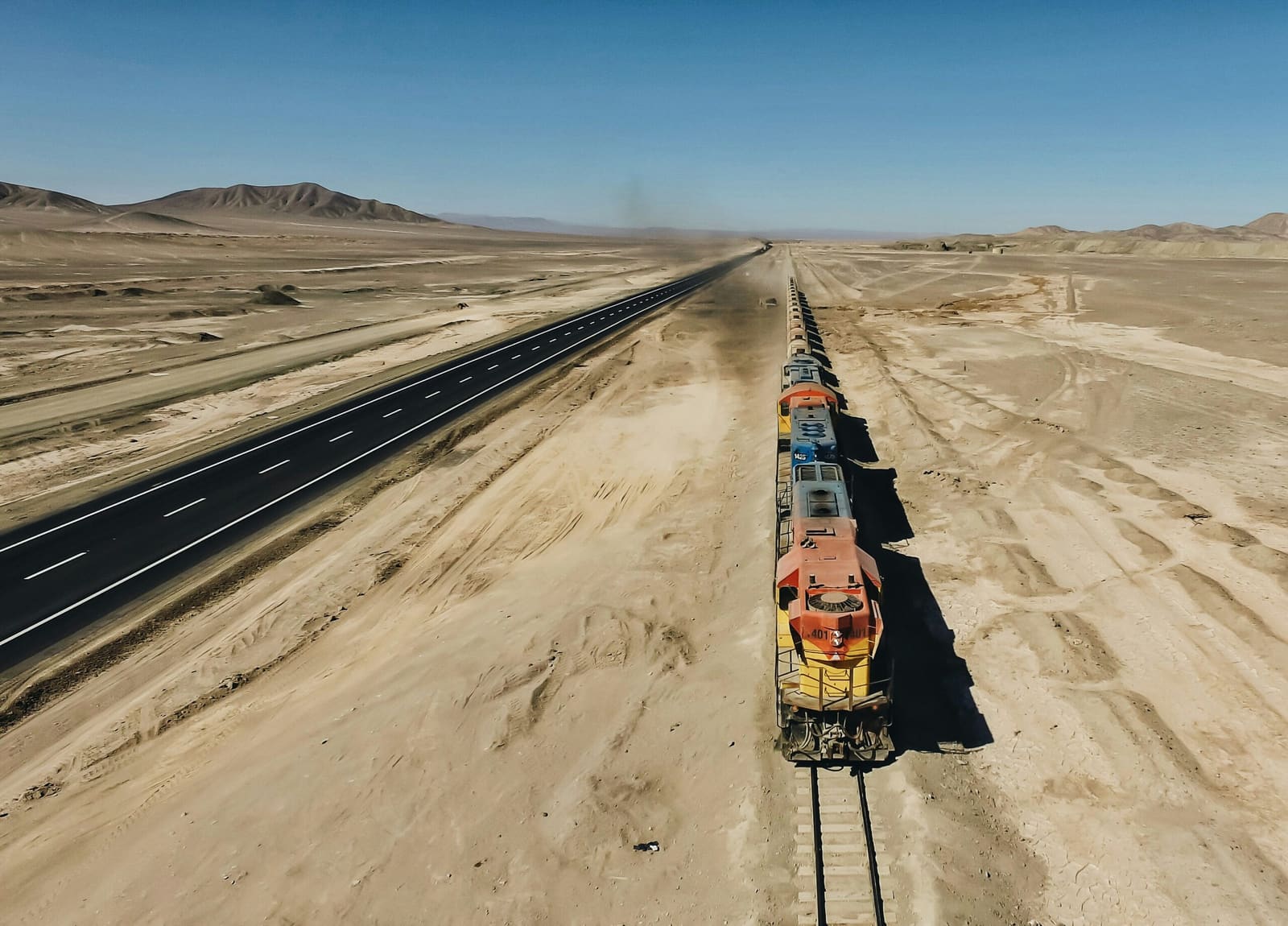 Freight train crossing open steppe on a single line of track, Central Asia