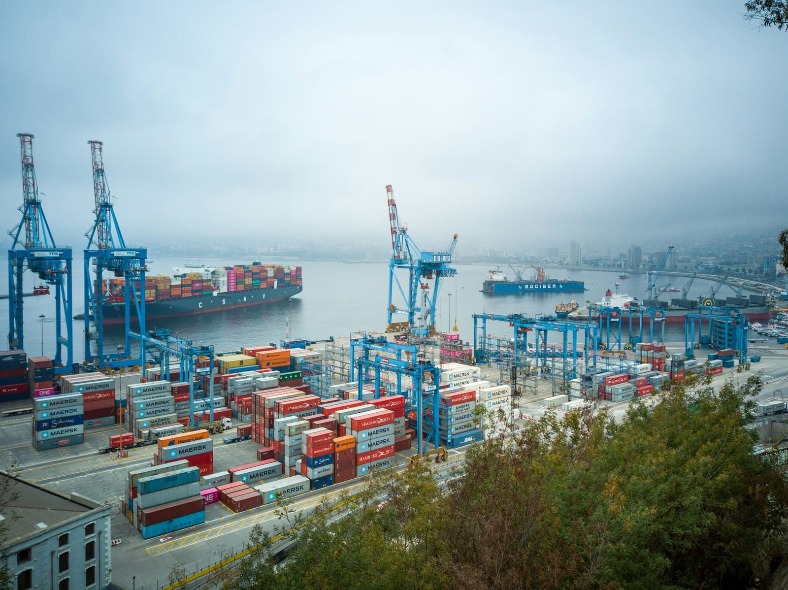 Container cranes and quayside terminal seen through coastal haze
